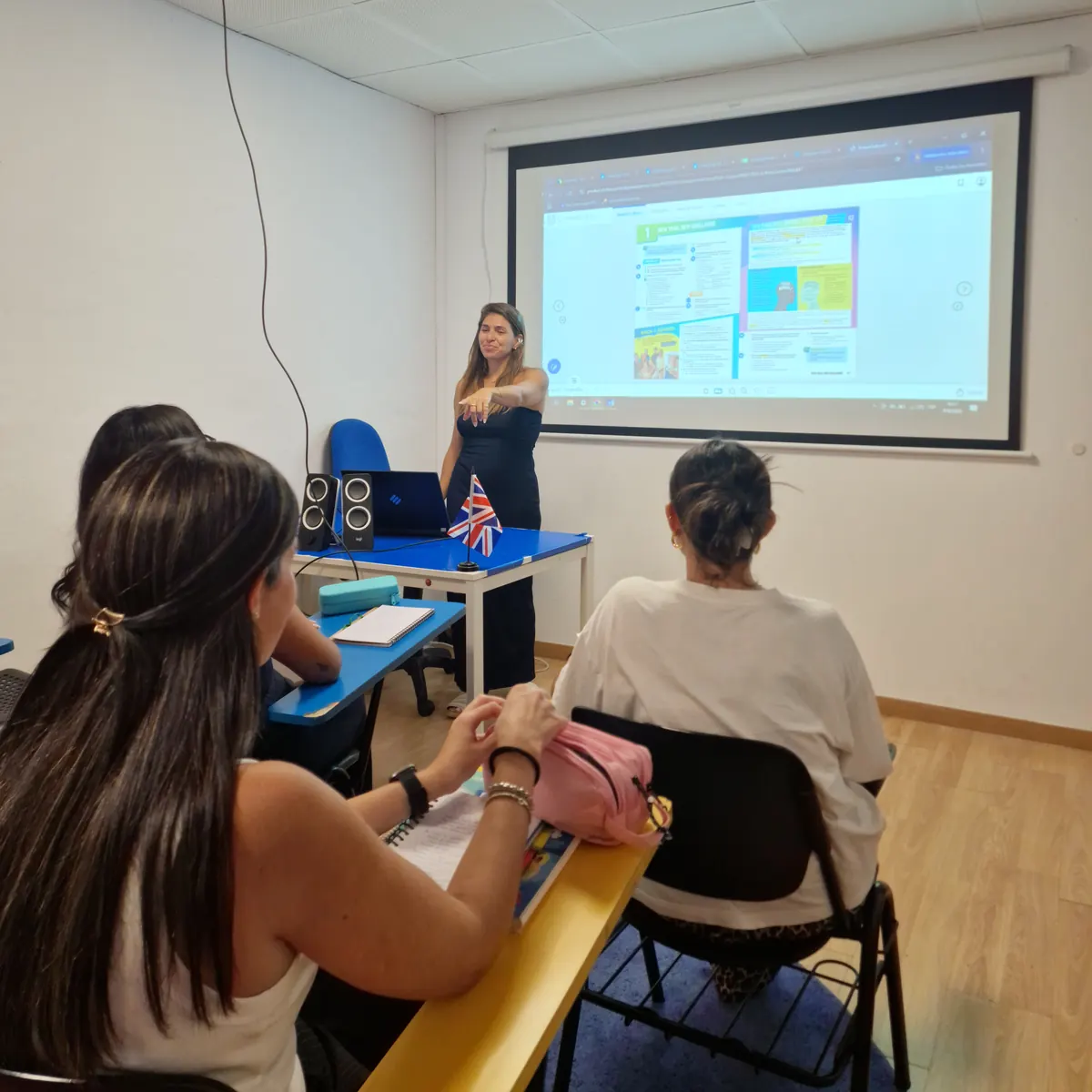 Profesora explicando junto al proyector a un grupo reducido de alumnas